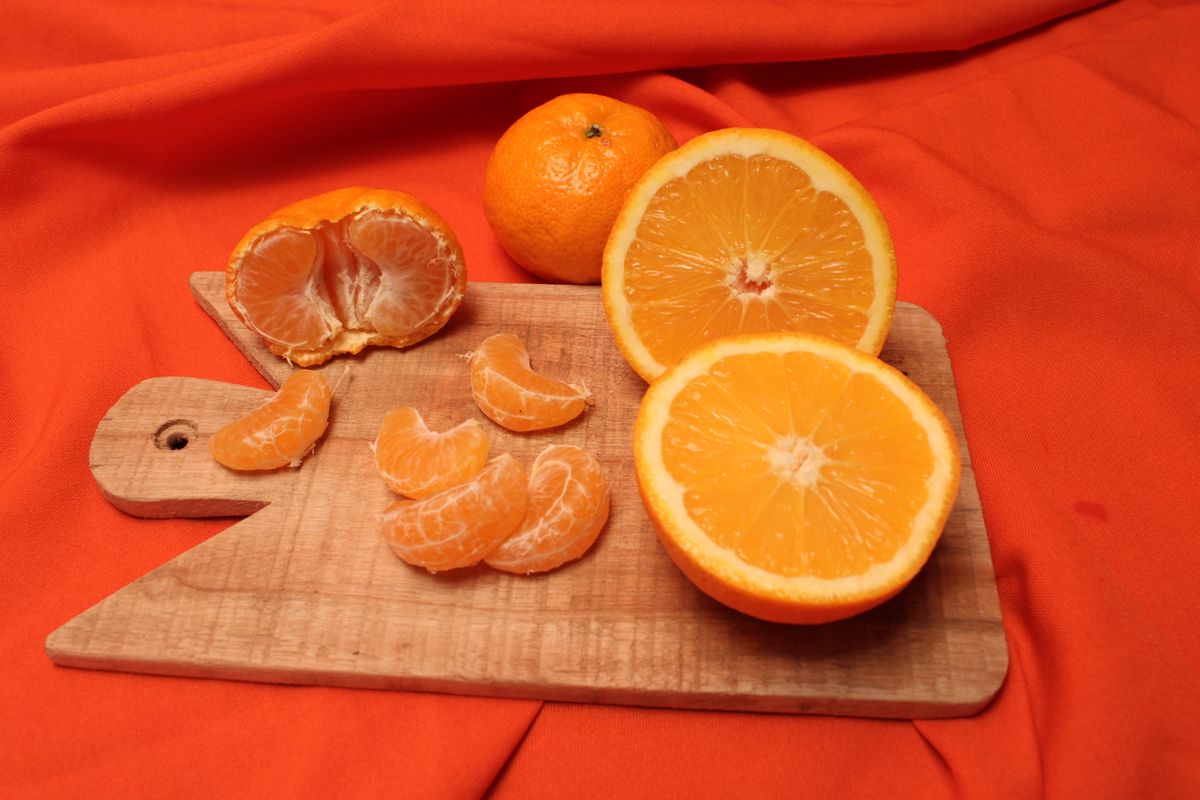 a bright orange orange peel next to a laboratory beaker
