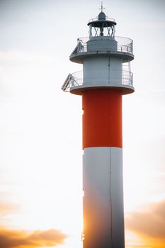 Silhouetted El Rompido Lighthouse at sunset, capturing the serene coastal beauty of Spain.
