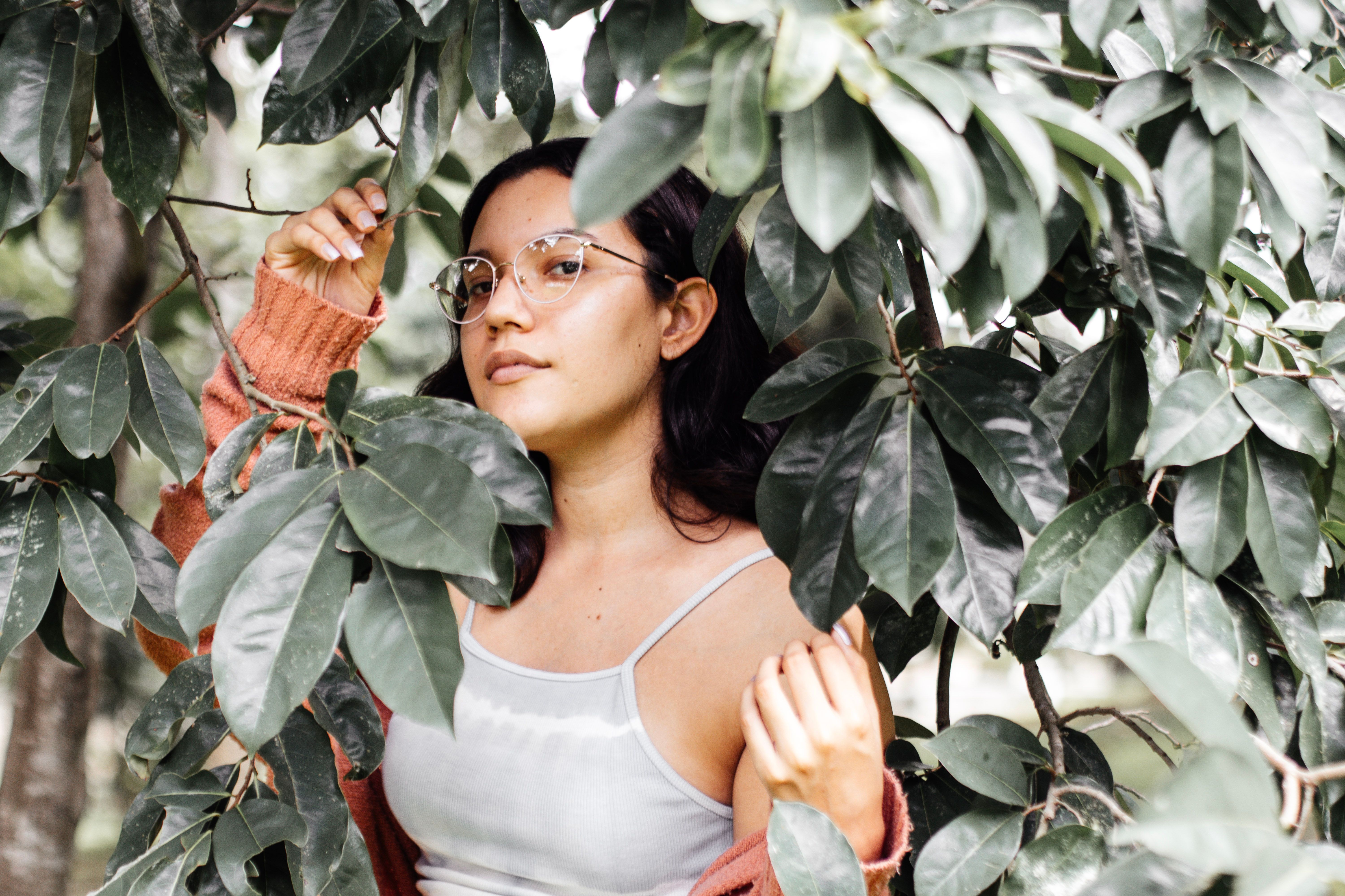Brunette in White Top and Cardigan Standing under Tree · Free Stock Photo