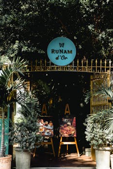 Discover the inviting entrance of a café surrounded by lush greenery in Ho Chi Minh City, Vietnam.