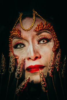 Close-up of a woman with intricate Halloween makeup and costume, evoking an intense and scary expression.