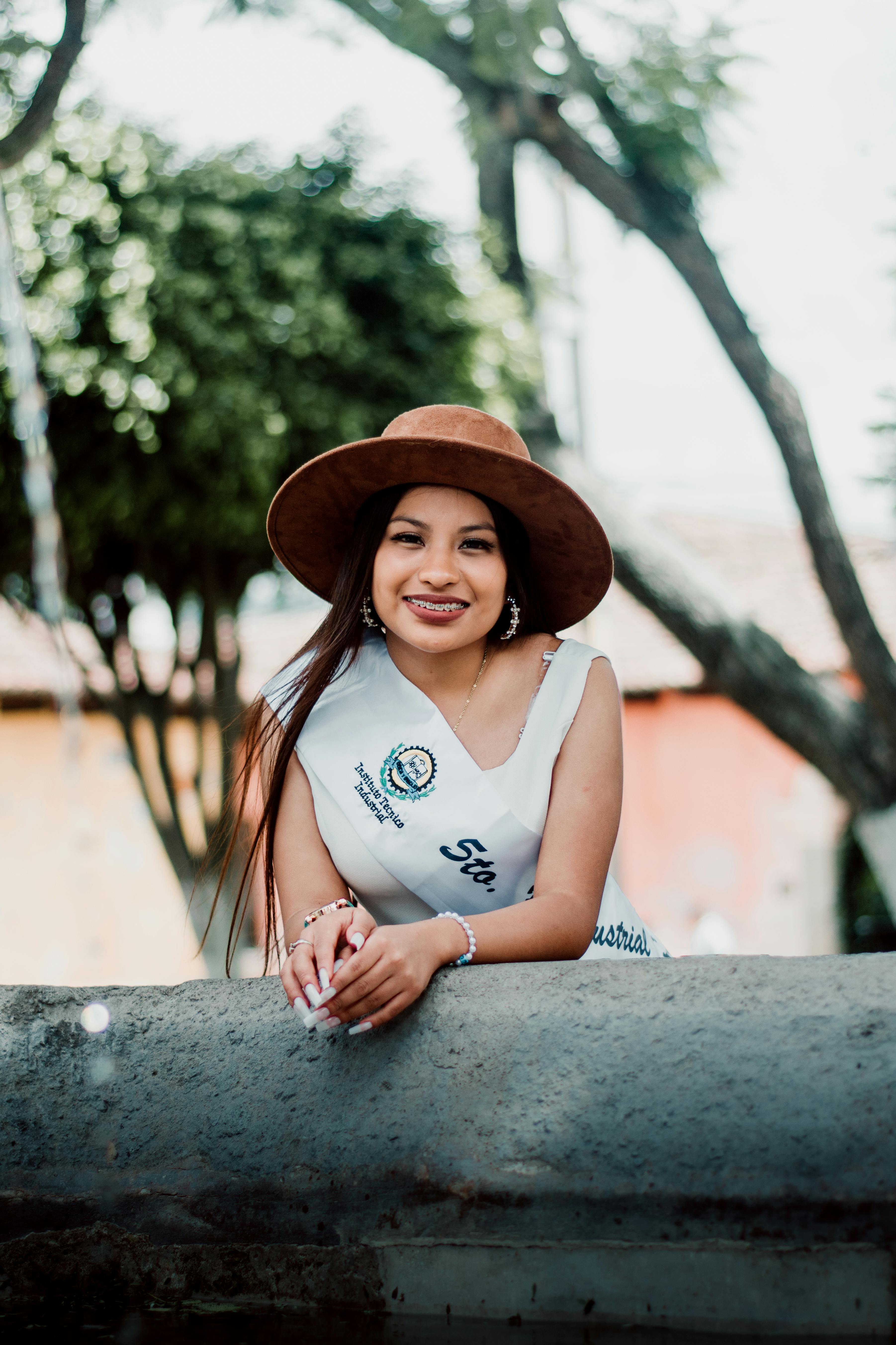 Smiling young woman wearing a brown hat enjoys sunny day in Antigua Guatemala.