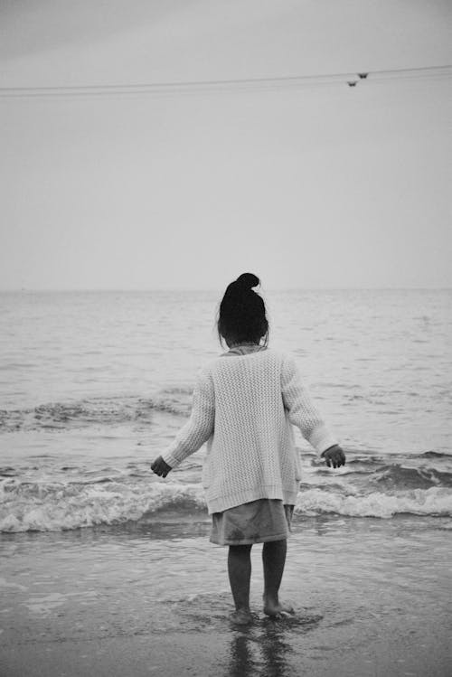 Back View of Girl Standing on Sea Shore in Black and White