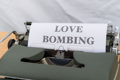 A typewriter with a love bombing paper on it