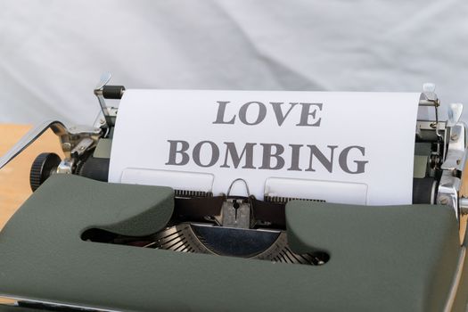 A typewriter with a love bombing paper on it