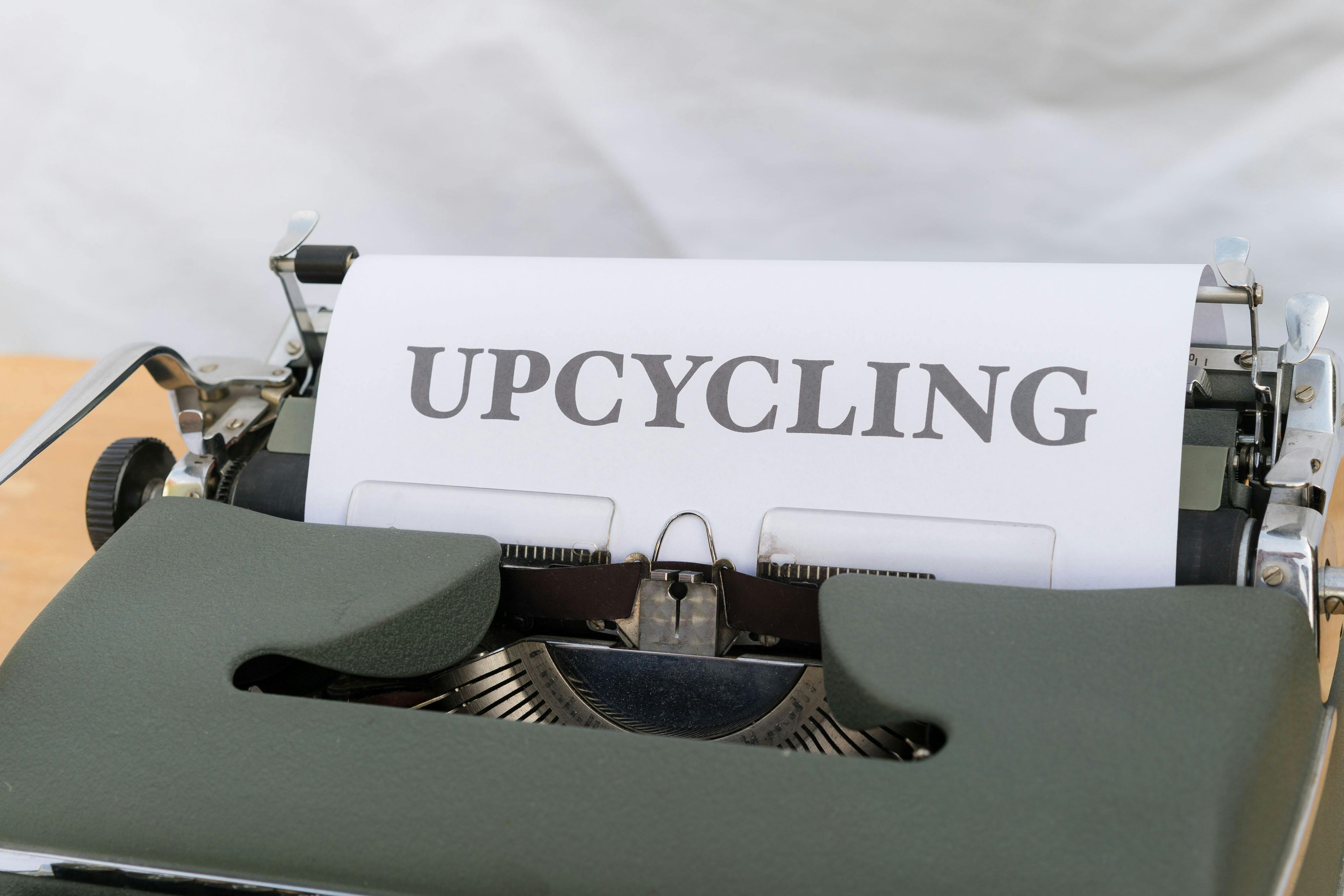 a typewriter with a paper that says upcycling