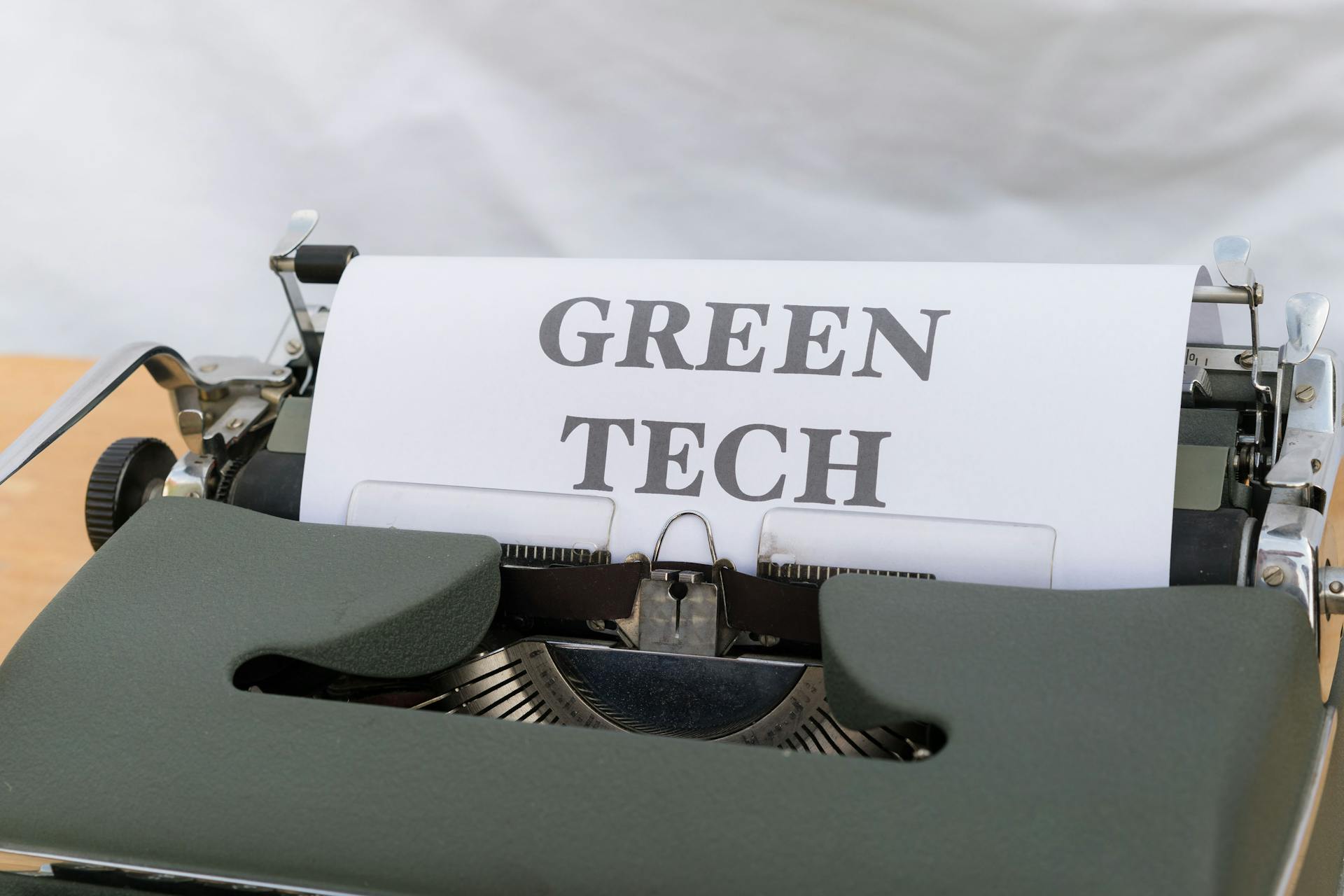 Vintage typewriter displaying the text 'Green Tech', symbolizing eco-friendly innovations.