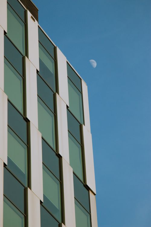 Free Contemporary office building with the moon in the sky in Wrocław, Poland. Stock Photo