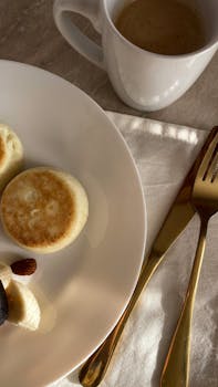 A close-up view of a breakfast plate with pancakes and coffee in a sophisticated setting. Perfect for food photography.