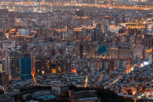 Free Aerial view of a bustling cityscape at twilight with illuminated buildings creating a vibrant urban atmosphere. Stock Photo
