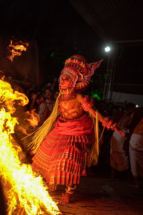 Free A vibrant Hindu dancer performs near a fire, showcasing traditional attire and spirituality during a night festival. Stock Photo