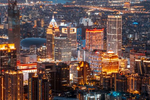 Free Aerial view of a brightly lit urban skyline at night, showcasing modern skyscrapers and city lights. Stock Photo