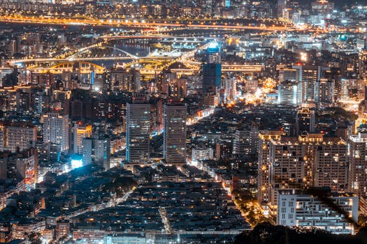 Aerial view of a bustling urban cityscape illuminated at night showcasing vibrant skyscrapers.