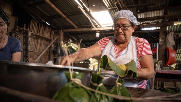 Woman preparing traditional food in a rustic kitchen, San Martín, Peru.
