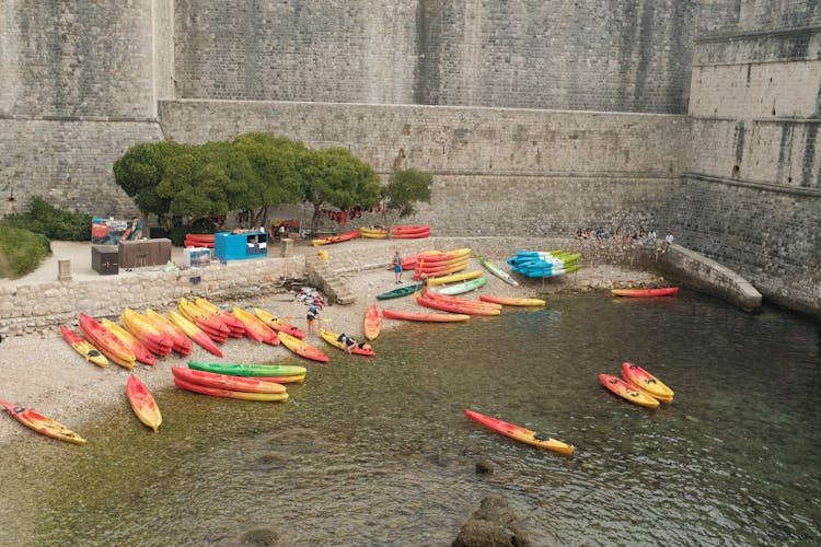 Canoes On Beach By Stone Wall