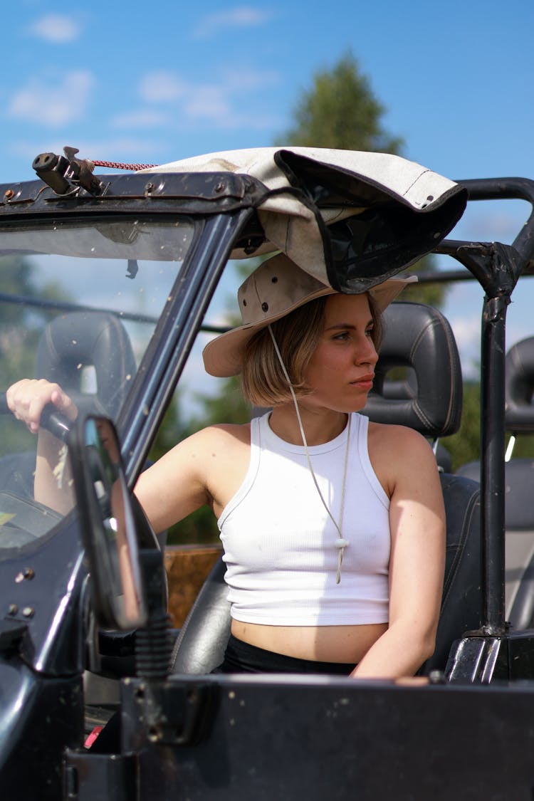 Young Woman Sitting In A Car With The Roof Down