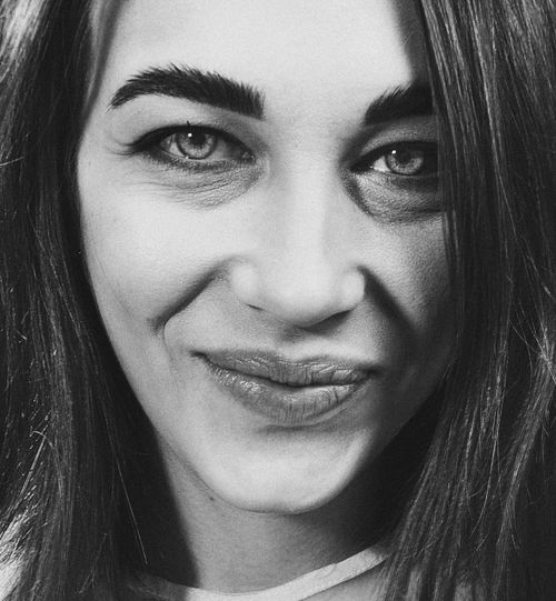 Free Monochrome close-up portrait showcasing a woman's confident expression and subtle smile. Stock Photo