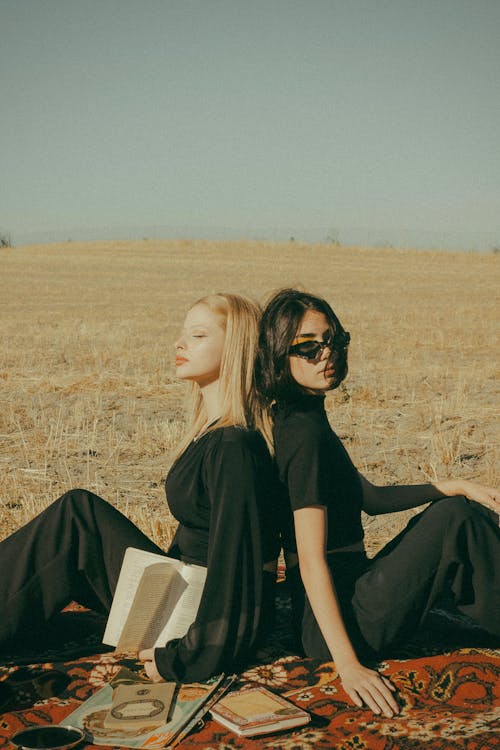 Two Women Sitting Back to Back 