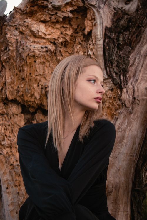 Free Model posing elegantly in black attire against a natural Ankara backdrop. Stock Photo
