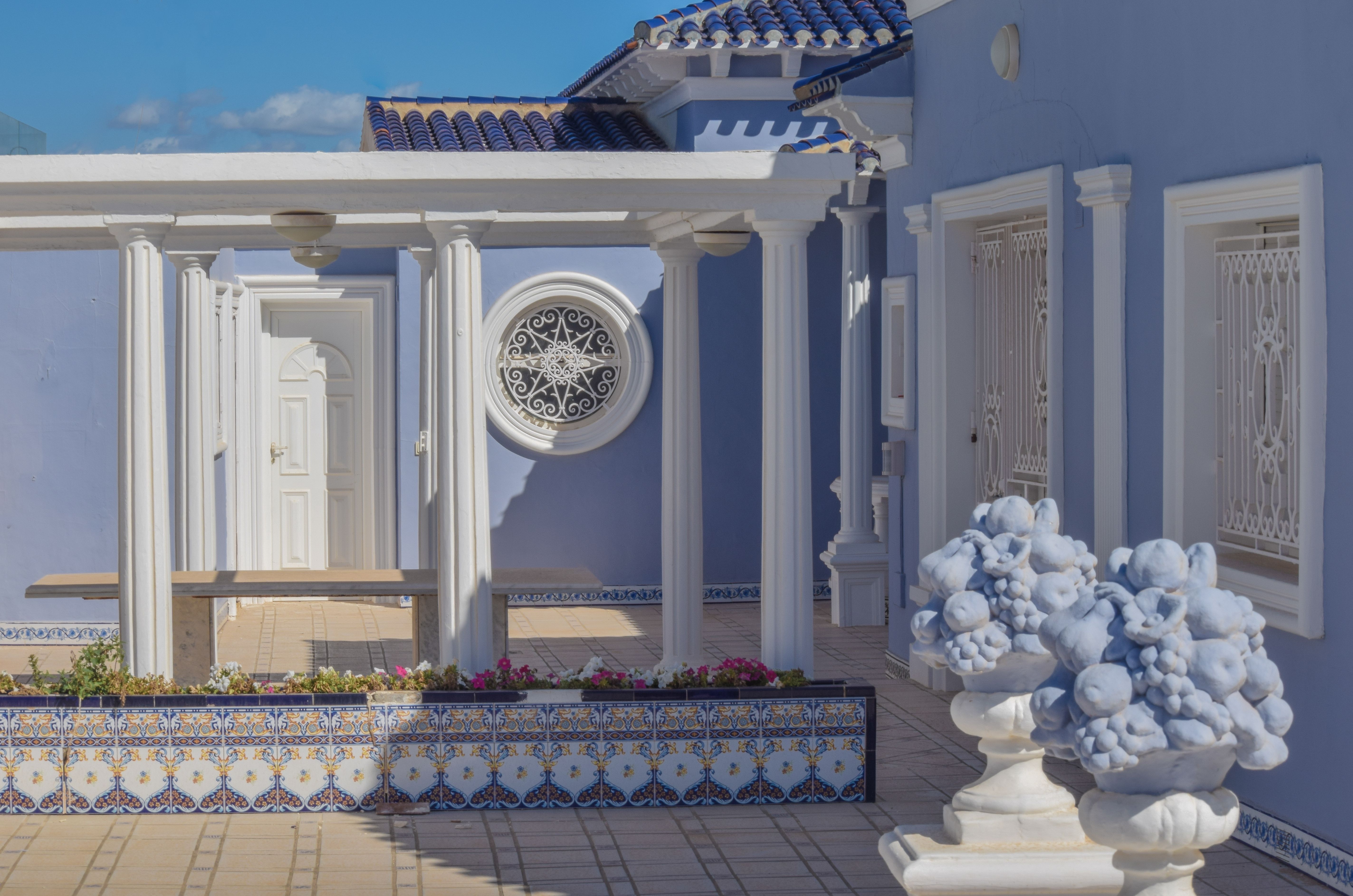 Classic Mediterranean villa with blue hues and white columns, perfect for a summer vacation.