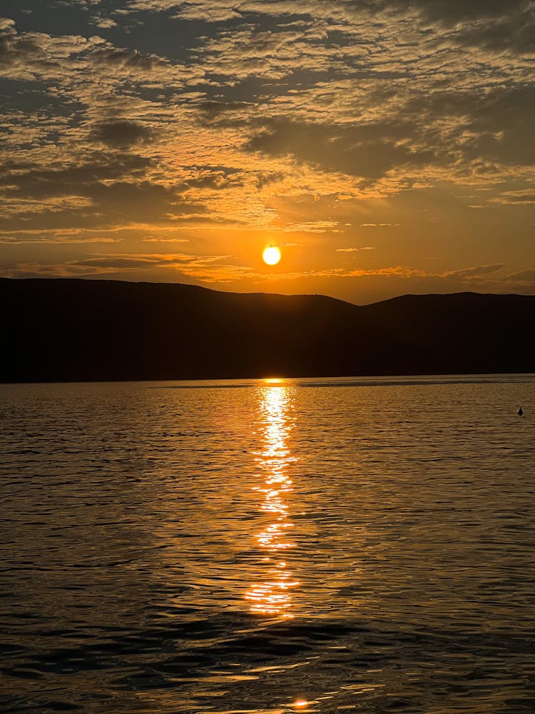 Lake And Silhouette Of Hills At Sunset 