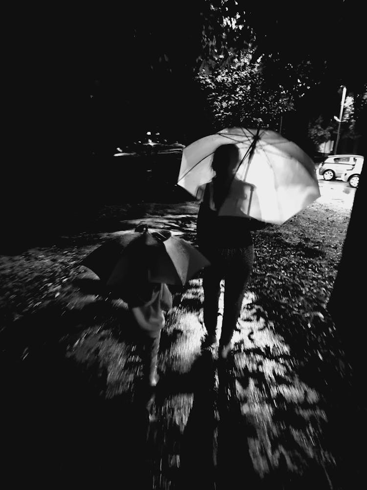 Woman Walking With A Child In The Rain 