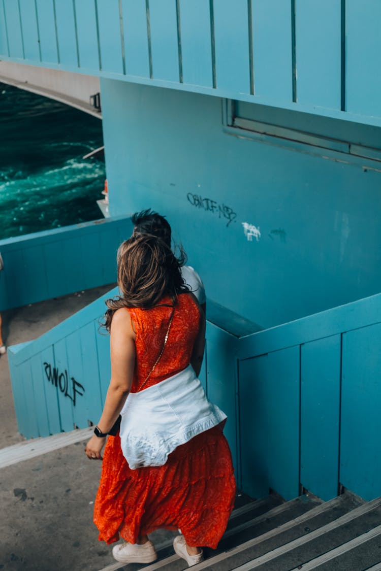 Back View Of A Woman Walking Down The Stairs 