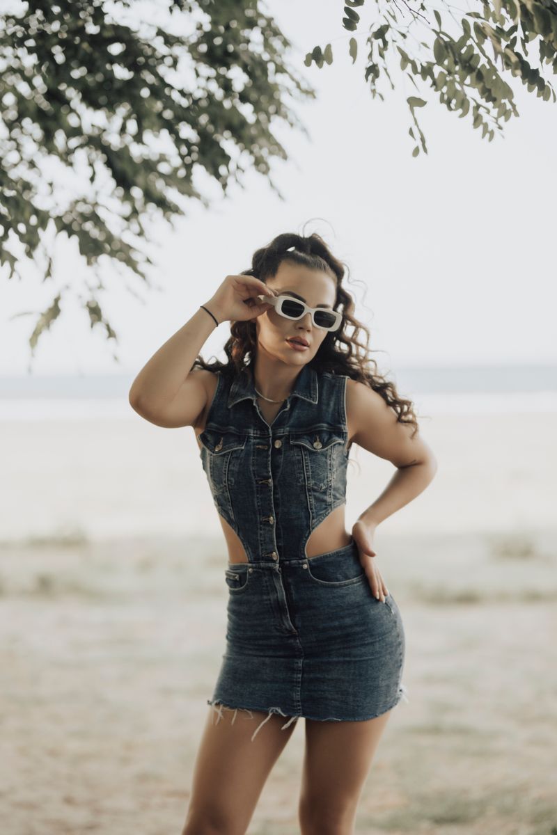 Woman in a denim dress wearing sunglasses