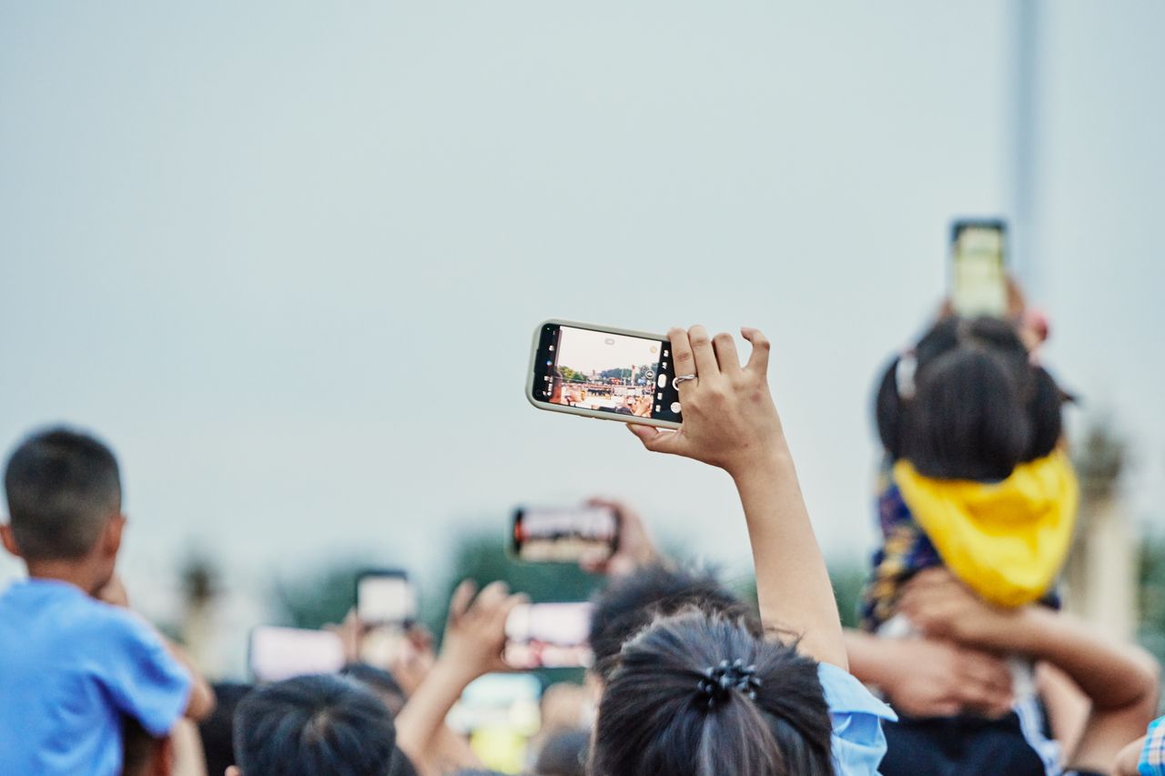 a lively crowd capturing an event on smartphones showcasing modern dig