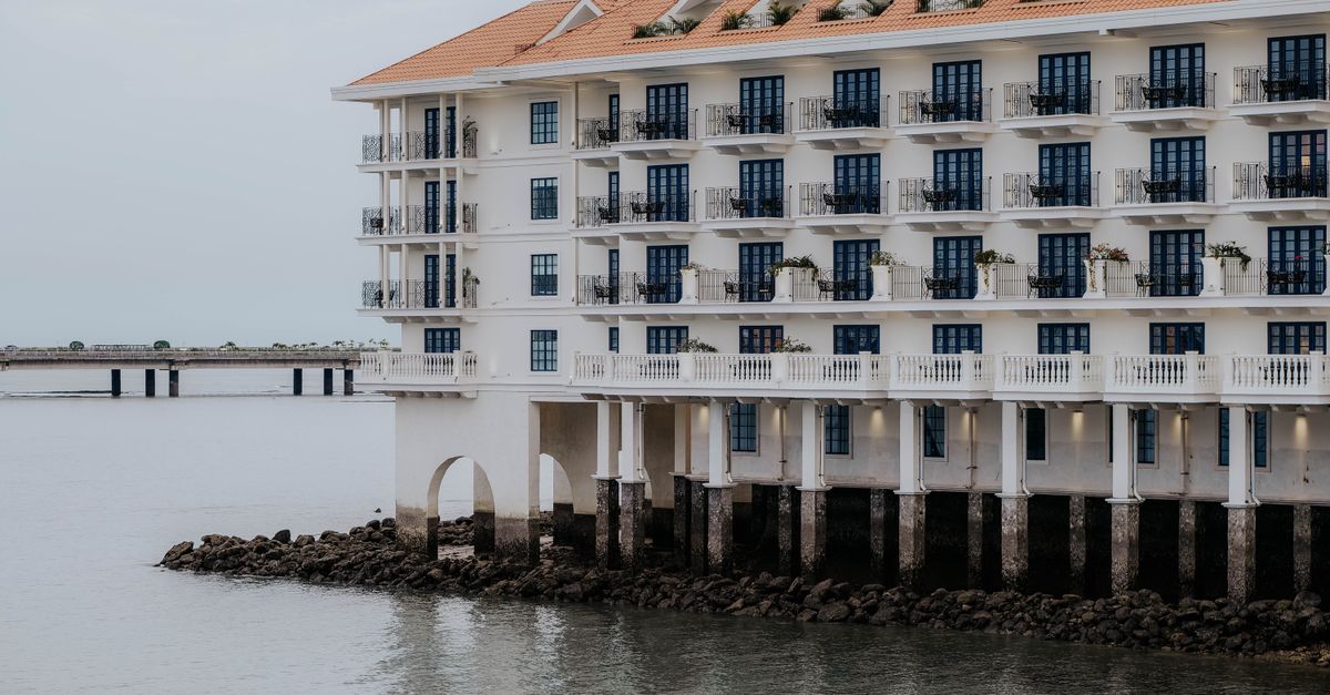 Elegant waterfront hotel facade in Panama City with ocean view and classic architecture.