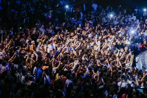 Free A vibrant crowd enjoying a live concert with phones raised to capture the performance. Stock Photo