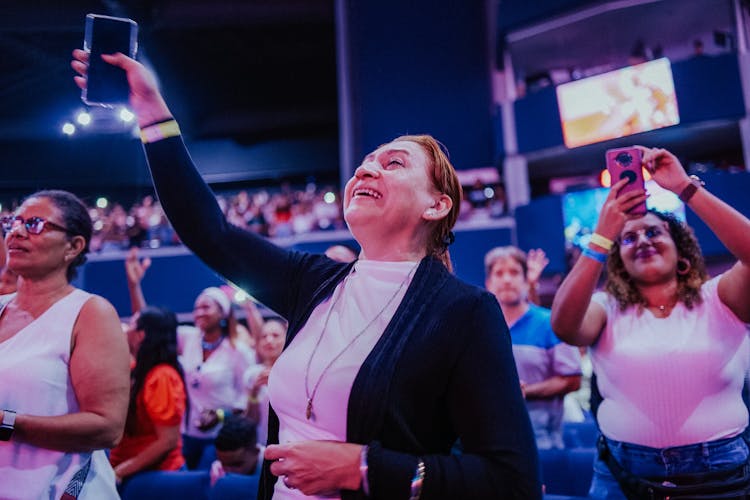 Woman In A Concert Holding Up Her Phone