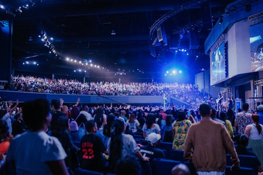 Energetic concert scene with diverse audience enjoying live music in a packed indoor arena.