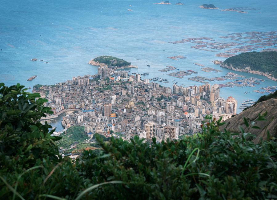 Stunning aerial shot of Fuzhou city and coastline, depicting urban architecture and sea farms.