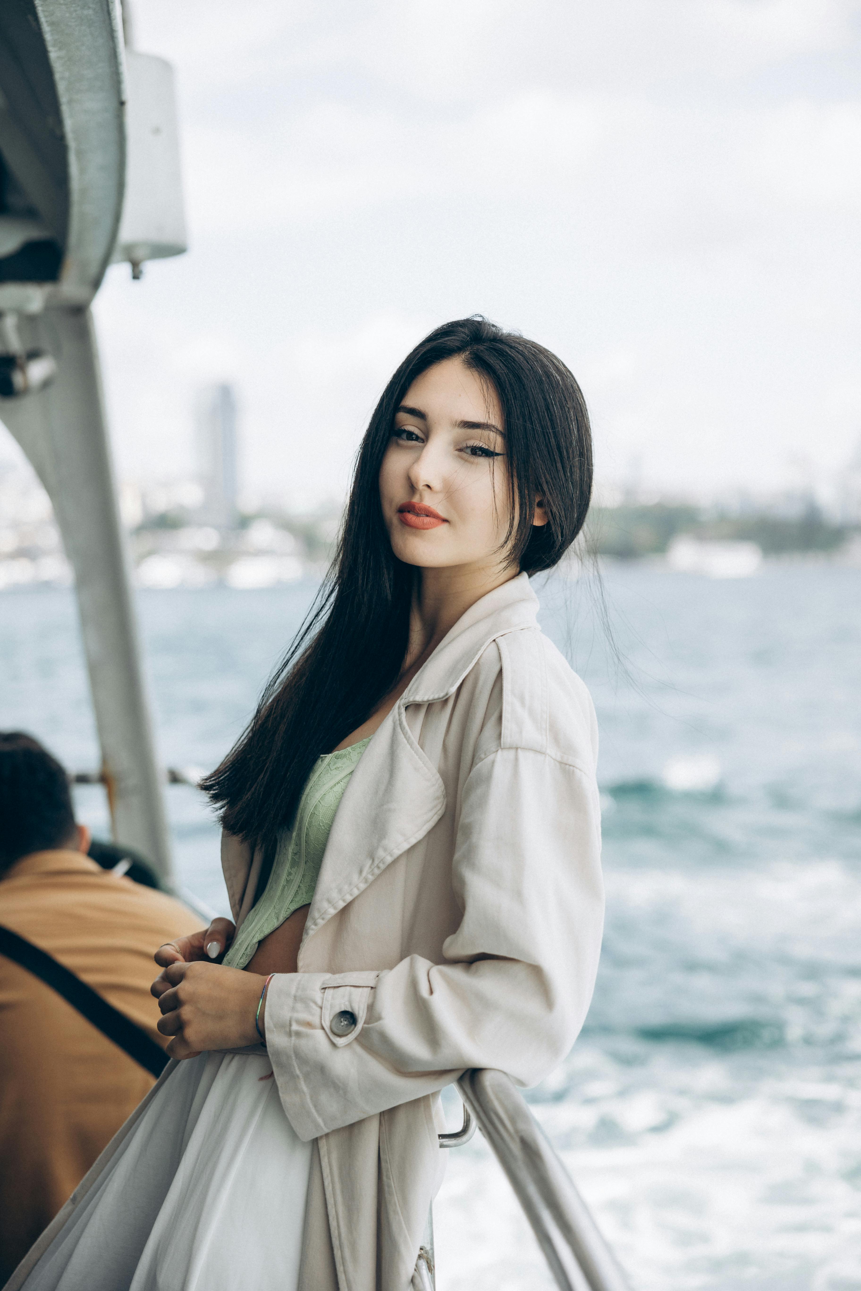 a woman in a white coat standing on a boat