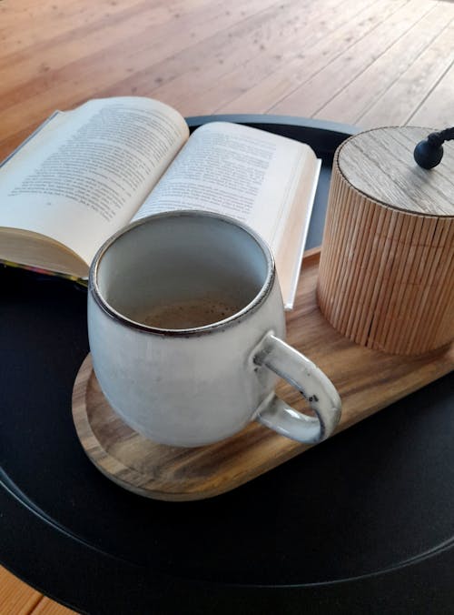 Still Life with a Coffee Mug and Open Book on a Table