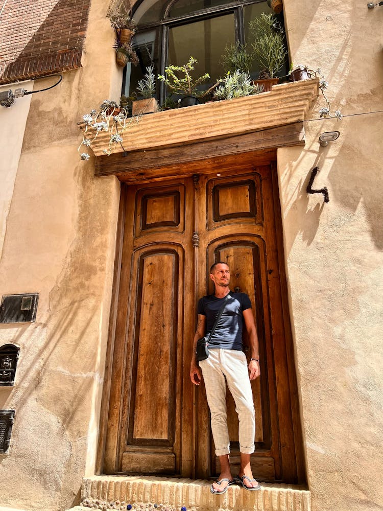 Man Standing On A Step By A Wooden Door