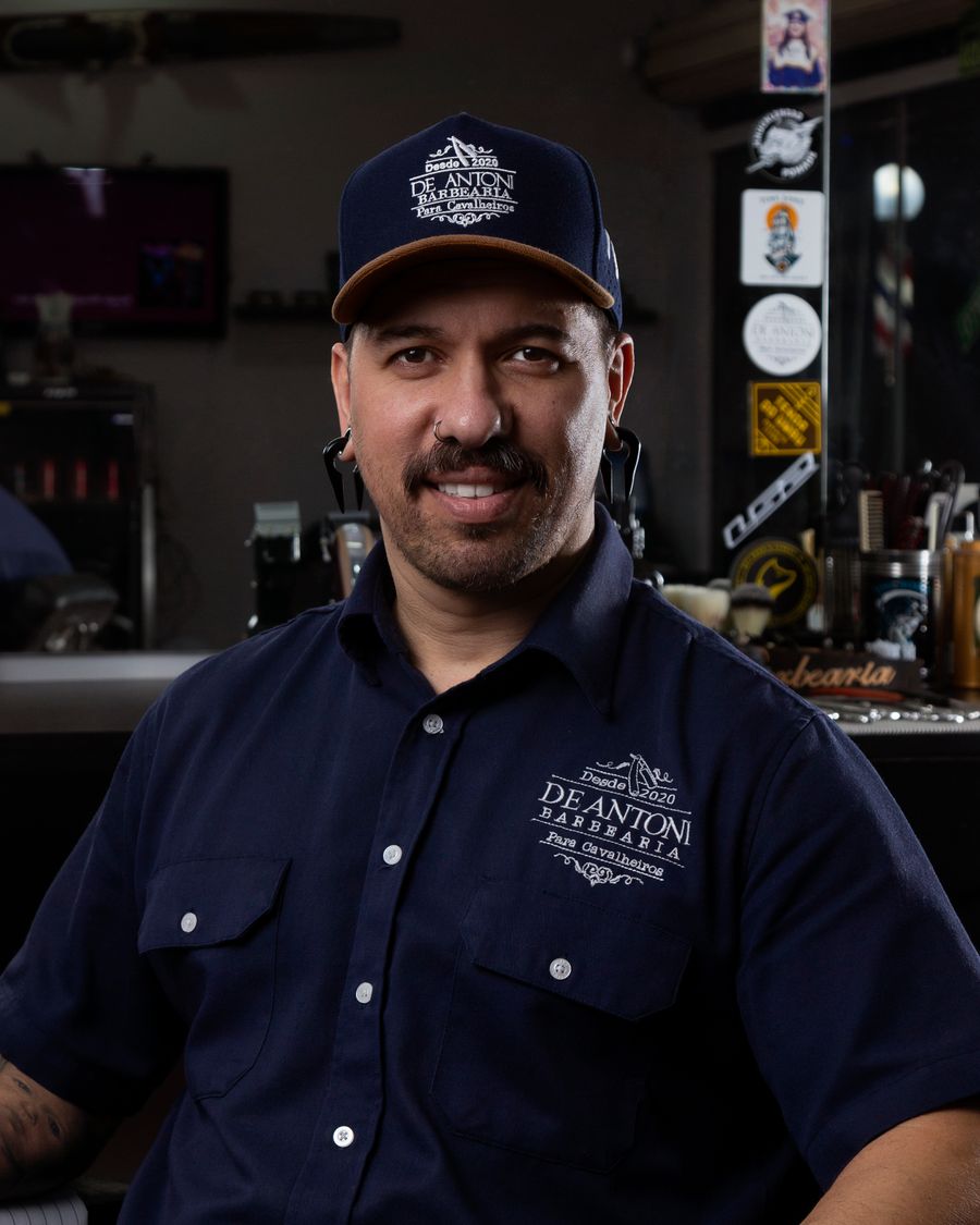 Barbeiro sorrindo na barbearia