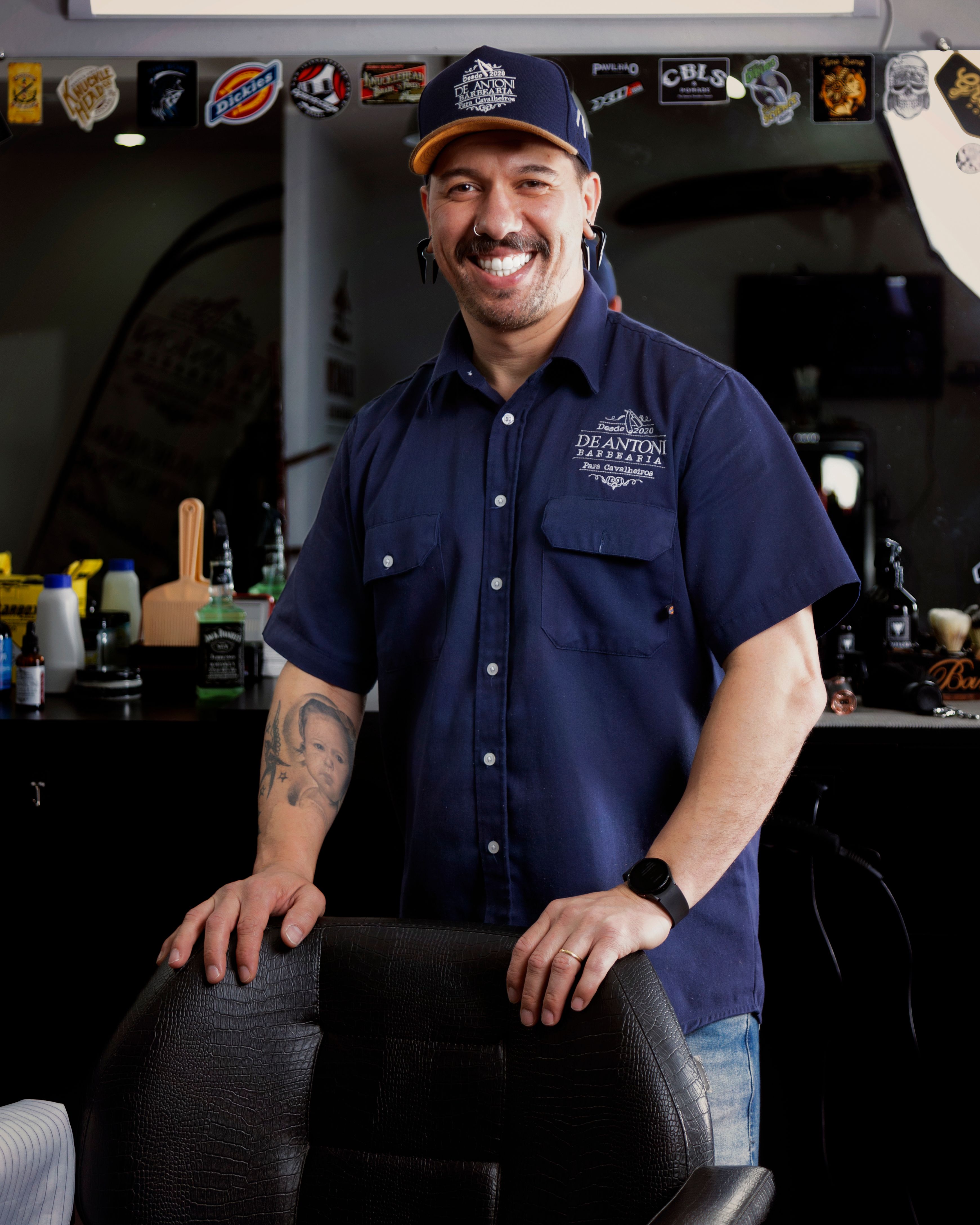 A smiling barber standing in his barbershop