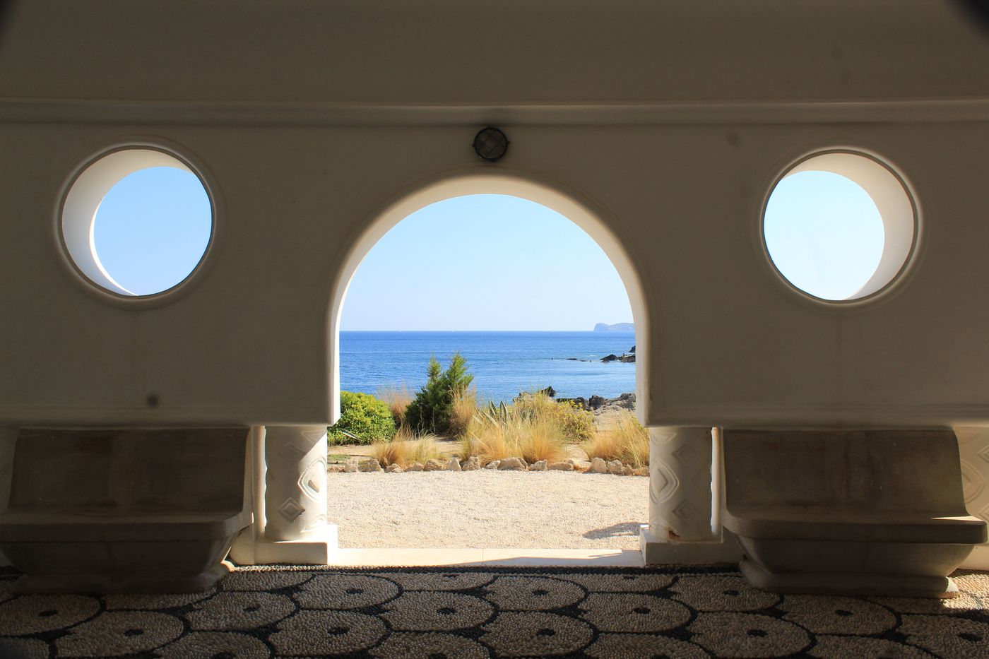 Porthole windows and an arch opening onto the sea in a Sitges house
