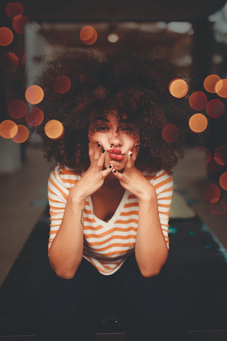 Woman Sitting While Holding Her Cheeks