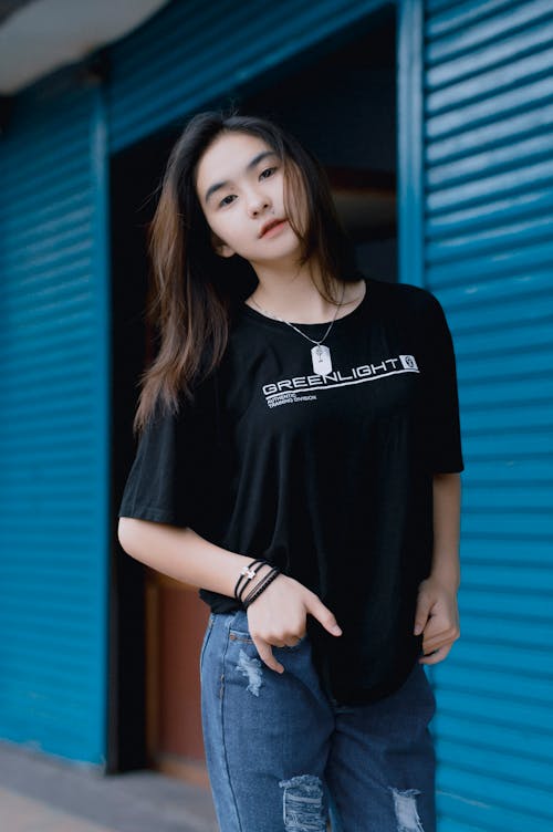 Young Woman Posing in Black T-Shirt and Blue Jeans