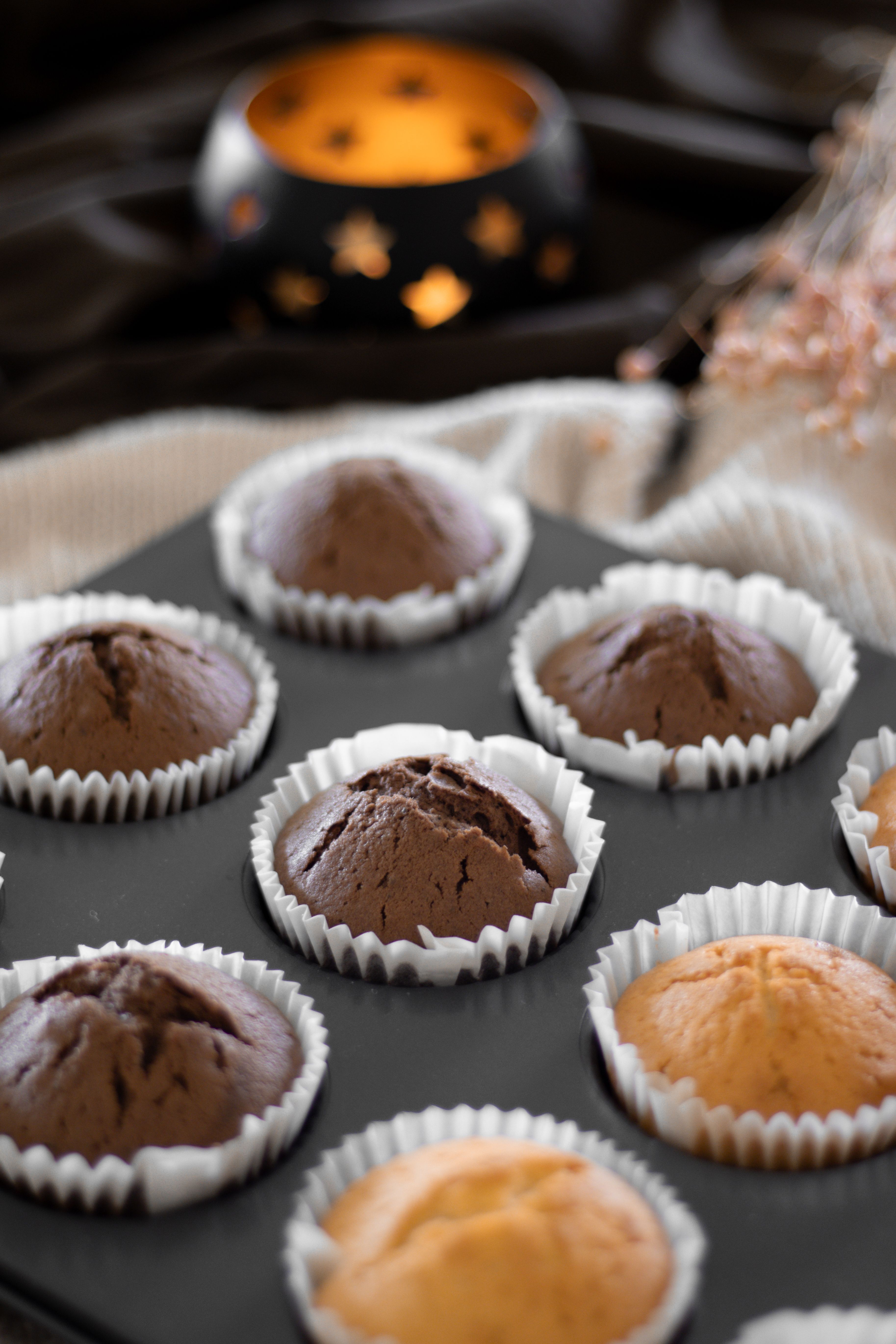 Appetizing chocolate and vanilla muffins freshly baked in a dark moody setting.