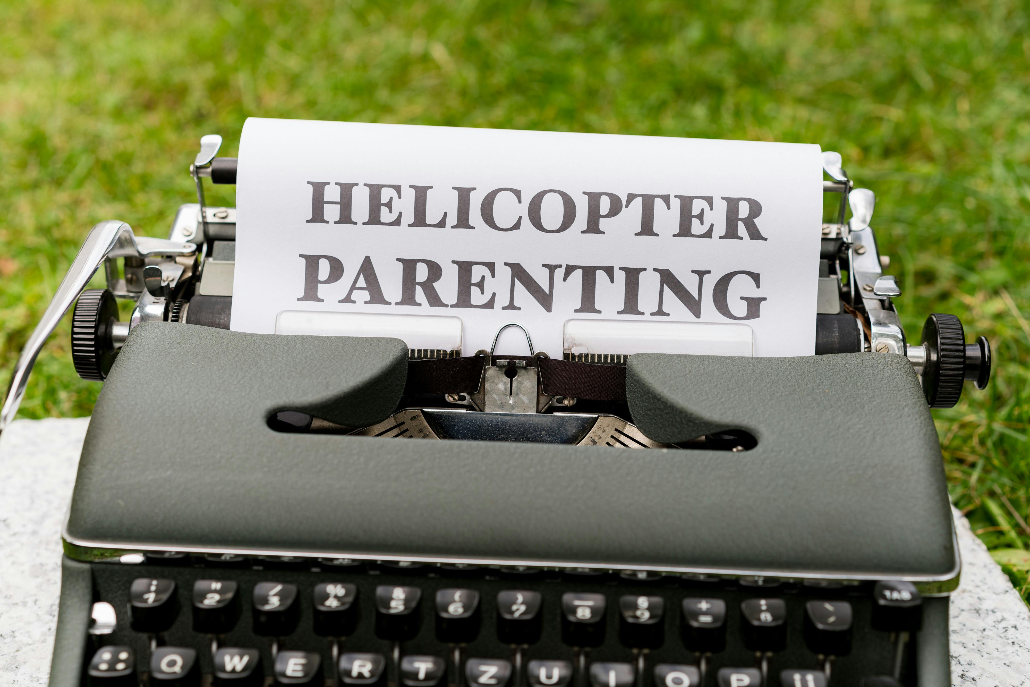 a typewriter with the words helicopter parenting on it