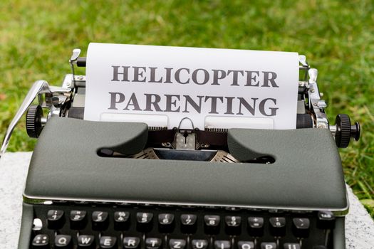 A typewriter with the words helicopter parenting on it