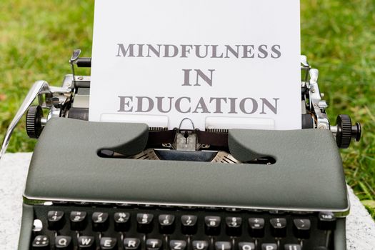 A vintage typewriter showcasing 'Mindfulness in Education' concept outdoors.