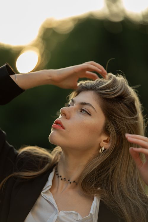 Free Elegant portrait of a blonde woman outdoors in soft sunlight, showcasing natural beauty and grace. Stock Photo