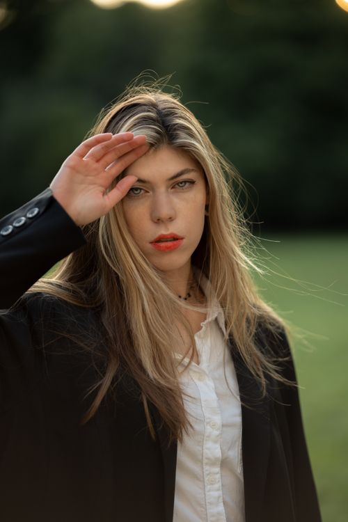 Free Elegant young woman with blonde hair posing outdoors in a black blazer during the daytime. Stock Photo