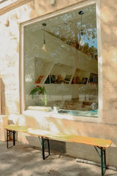 Modern store window with outdoor seating, reflecting urban Paris scene.