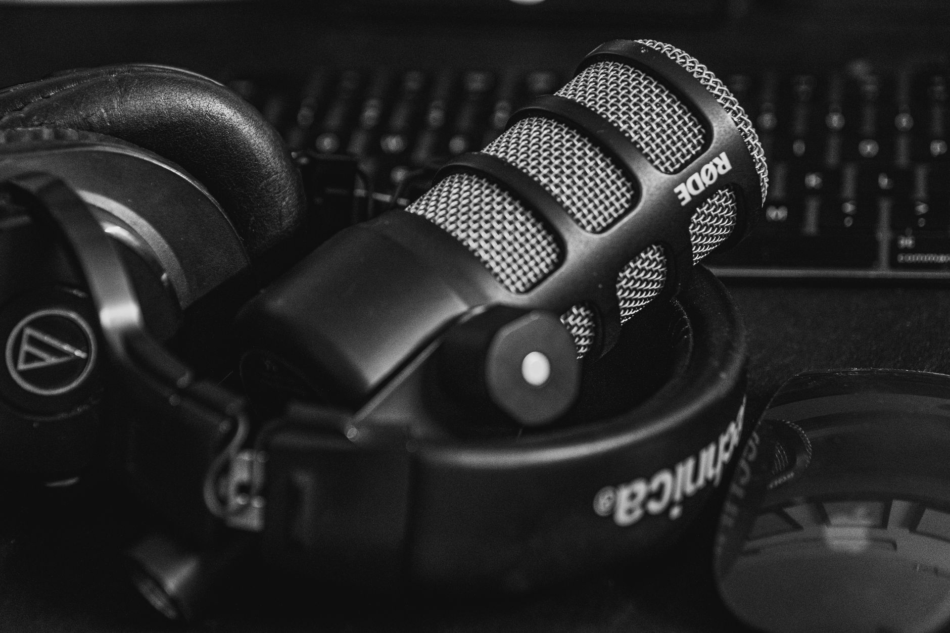 Close-up of a studio microphone and headphones in a black and white composition, perfect for audio and podcast themes.
